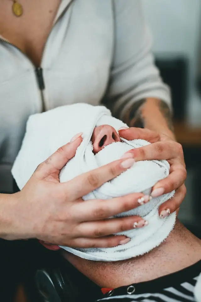 A male client relaxing with a hot steamed towel on his face at a salon